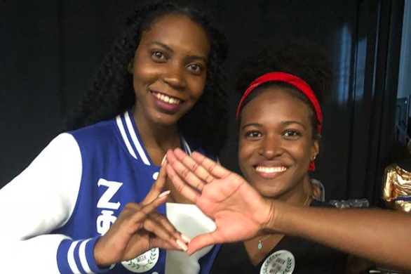Two Greek Life students combine their sorority hand signs